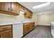 Kitchen features wood cabinets, white appliances, gray flooring, and a skylight at 7607 Farm View E Cir, Indianapolis, IN 46256