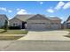 Charming single story home featuring stone accents, three car garage and well manicured lawn at 943 Foxglove St, Lebanon, IN 46052