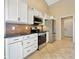 Well-lit kitchen featuring white cabinets, stainless steel appliances, and ceramic tile flooring at 943 Foxglove St, Lebanon, IN 46052