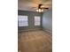 Blue bedroom with carpet flooring, two windows, and ceiling fan at 10072 Graceful Landing Dr, Indianapolis, IN 46234