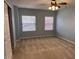 Bright bedroom featuring carpet, two windows providing natural light, and a ceiling fan at 10072 Graceful Landing Dr, Indianapolis, IN 46234