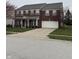 Charming brick home features a two-car garage, well-kept lawn, and mature landscaping at 10072 Graceful Landing Dr, Indianapolis, IN 46234