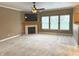Spacious living room with a cozy fireplace, ceiling fan, and large windows, perfect for relaxing and entertaining at 10072 Graceful Landing Dr, Indianapolis, IN 46234