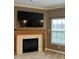 Living room showcasing a fireplace with wood mantle, TV, and large window at 10072 Graceful Landing Dr, Indianapolis, IN 46234
