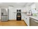 Kitchen featuring stainless appliances, modern white cabinets, counter space and wood look flooring at 1114 S Avon Ave, Avon, IN 46123