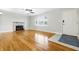 Sun-filled living room with hardwood flooring, fireplace, ceiling fan, and a front door at 1114 S Avon Ave, Avon, IN 46123