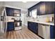 Modern kitchen featuring stainless steel appliances, navy cabinets, and sleek backsplash at 118 W Fordice St, Lebanon, IN 46052