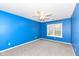 Bright bedroom with blue walls, gray carpet, a ceiling fan, and a window overlooking the outdoors at 12527 Trester Ln, Fishers, IN 46038