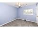 Bright, carpeted bedroom featuring a ceiling fan and natural light from the window at 12527 Trester Ln, Fishers, IN 46038