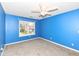 Bright bedroom with blue walls, gray carpet, a ceiling fan, and a window overlooking the outdoors at 12527 Trester Ln, Fishers, IN 46038