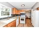 Bright kitchen features oak cabinets, granite countertops, white appliances, and a view to the living room at 12527 Trester Ln, Fishers, IN 46038