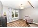 Cozy living room nook featuring a reading chair, window, and view of the landscaped backyard at 12527 Trester Ln, Fishers, IN 46038