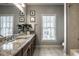 Well-lit bathroom featuring double sinks, granite countertops, and a large window for natural light at 12897 Queens Troop, Carmel, IN 46032