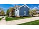 Charming home exterior with blue siding and brick accents, set amidst beautiful landscaping and mature trees at 12897 Queens Troop, Carmel, IN 46032