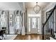 Bright foyer with hardwood floors, elegant chandelier, and staircase with rod iron banister at 12897 Queens Troop, Carmel, IN 46032