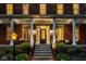 Inviting front porch with stately columns, seating, brick walkway, and manicured landscaping at 12897 Queens Troop, Carmel, IN 46032