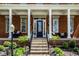 Inviting front porch with classic columns, comfortable seating, and beautiful landscaping, a warm welcome home at 12897 Queens Troop, Carmel, IN 46032