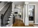 Inviting hallway with staircase, hardwood floors, and views into the living room and kitchen at 12897 Queens Troop, Carmel, IN 46032