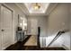 Hallway boasts dark hardwood floors, tray ceiling, console table, and staircase access at 12897 Queens Troop, Carmel, IN 46032