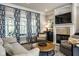 Bright and airy living room featuring a fireplace, hardwood floors, and large windows at 12897 Queens Troop, Carmel, IN 46032