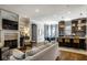 Open-concept living area with a fireplace, adjacent to a modern kitchen and dining space at 12897 Queens Troop, Carmel, IN 46032
