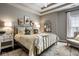 Elegant main bedroom featuring a tray ceiling, decorative wall mirror, and neutral color palette at 12897 Queens Troop, Carmel, IN 46032