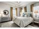 Bright main bedroom with a trey ceiling, floral wallpaper, and plush bedding for relaxation at 12897 Queens Troop, Carmel, IN 46032