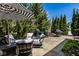 Outdoor patio featuring a striped umbrella, comfortable seating, grill and well-maintained landscaping at 12897 Queens Troop, Carmel, IN 46032