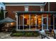 Outdoor screened-in sunroom with an umbrella table, and string lights providing evening ambiance at 12897 Queens Troop, Carmel, IN 46032