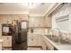 This kitchen features a black refrigerator, lots of cabinet space, and a stainless steel sink at 140 Kim Dr, Anderson, IN 46012
