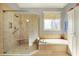 This bathroom features tile floors, tub, and separate glass enclosed shower and storage cabinet at 16129 Brookhollow Dr, Westfield, IN 46062