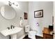 Charming powder room with a pedestal sink, round mirror and warm accents at 16129 Brookhollow Dr, Westfield, IN 46062