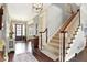 Inviting foyer with hardwood floors, a staircase with carpet runner, and elegant decor sets a sophisticated tone at 16129 Brookhollow Dr, Westfield, IN 46062