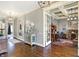 Hardwood hallway leading to a home office, complemented by decorative furniture, lighting, and soft gray walls at 16129 Brookhollow Dr, Westfield, IN 46062