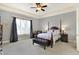 Cozy main bedroom featuring a four-poster bed, neutral carpet, and tray ceiling at 16129 Brookhollow Dr, Westfield, IN 46062