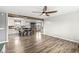 Bright, open-concept living room with wood flooring and a ceiling fan adjacent to a kitchen with white cabinets at 1636 N County Road 425 E, Avon, IN 46123