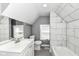 Bathroom featuring marble tile, gray walls, window, and white vanity and toilet at 1653 S Delaware St, Indianapolis, IN 46225