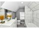 Bright bathroom featuring marble tile, gray walls, window, and white vanity and toilet at 1653 S Delaware St, Indianapolis, IN 46225