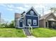 Charming blue two-story home with landscaped front yard and inviting entryway on a sunny day at 1653 S Delaware St, Indianapolis, IN 46225