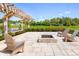 Backyard featuring a pergola, swing, seating, a fire pit, and professionally landscaped lawn at 17220 Cole Evans Dr, Noblesville, IN 46060