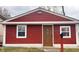 Charming single-story home with a red exterior, a decorative front door and well-maintained landscaping at 1921 W Michigan St, Indianapolis, IN 46222