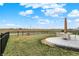 This backyard has a concrete patio with dining set, black metal fence, and a calming view of the pond at 19970 Edwick Dr, Westfield, IN 46074