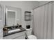 A bathroom featuring a shower curtain, toilet, vanity, mirror, black faucet, and a shelf at 19970 Edwick Dr, Westfield, IN 46074