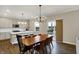 Open dining room next to modern kitchen, featuring pendant lighting, an island with bar seating and view to outdoors at 19970 Edwick Dr, Westfield, IN 46074
