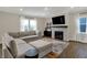 Bright living room featuring a comfortable sofa, fireplace, mounted TV, and large windows at 19970 Edwick Dr, Westfield, IN 46074