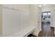 This mudroom features a white bench and coat rack, providing a convenient space to store outdoor essentials at 19970 Edwick Dr, Westfield, IN 46074