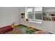 A well-organized playroom with built-in shelves, a window seat, toys, and a colorful rug at 19970 Edwick Dr, Westfield, IN 46074