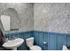 A stylish powder room featuring blue wainscoting, floral wallpaper, and a pedestal sink at 19970 Edwick Dr, Westfield, IN 46074