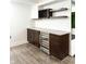 Stylish bar area with custom wine storage, dark wood cabinets, light countertops, and a built-in wine refrigerator at 2037 Ruckle St, Indianapolis, IN 46202
