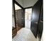 Modern bathroom featuring black door, white basketweave tile, and view of living area with hardwood floors and natural light at 2037 Ruckle St, Indianapolis, IN 46202